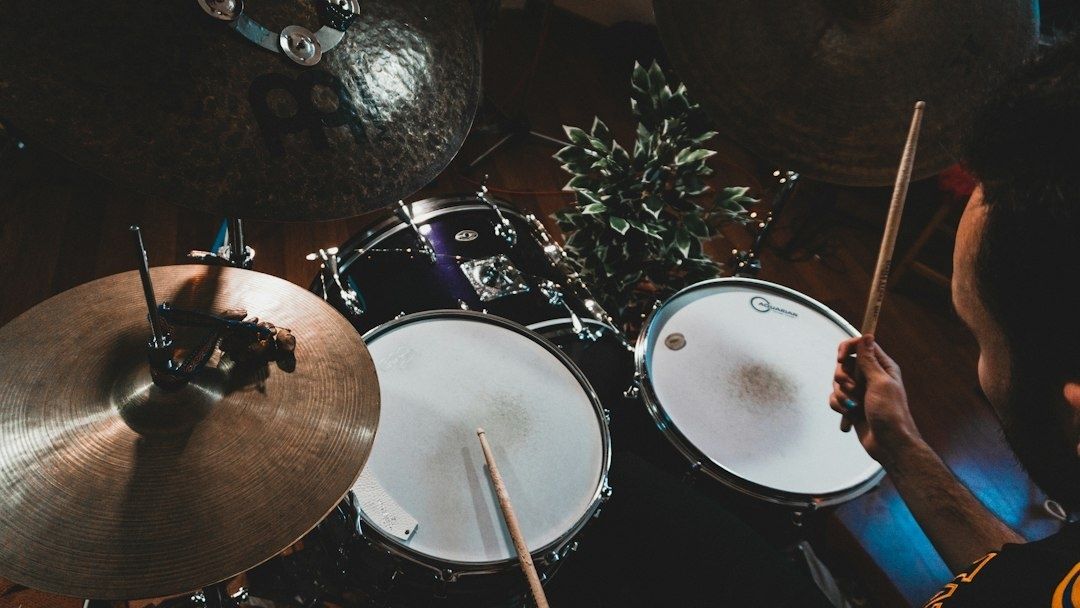 Overhead view of a drummer playing a kit with cymbals and toms